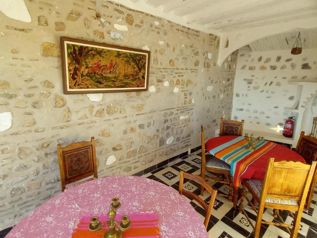 une chambre avec une table et un tableau sur le mur dans l'établissement RIAD LA SANTA, à Chefchaouen