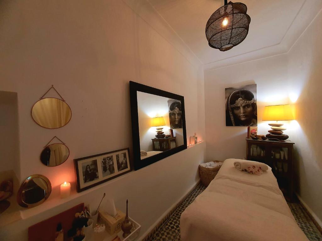 une chambre avec un lit, un miroir et des lumières dans l'établissement Riad Dar Zouar & Spa, à Marrakech