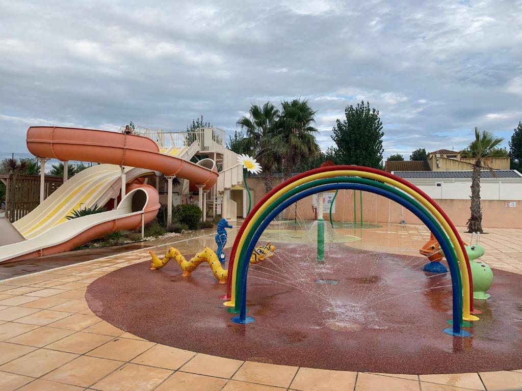 un parc aquatique avec un toboggan et un parc aquatique dans l'établissement Mobil-home climatisé à Valras Plage dans le camping 4 étoiles les Sables du midi à 800m de la plage, à Sérignan