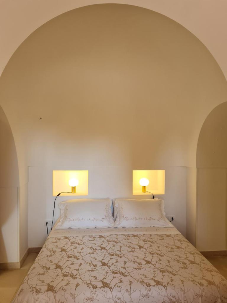 une chambre avec un lit avec deux lampes dessus dans l'établissement Trulli Martina, à Martina Franca 44 autres photos