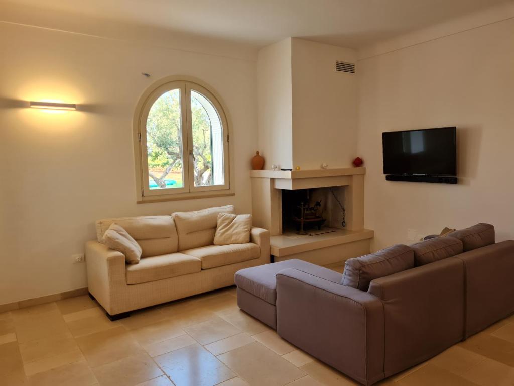 un salon avec deux canapés et une télévision dans l'établissement Trulli Martina, à Martina Franca