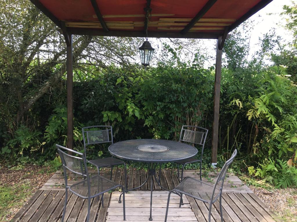 une table et des chaises sur une terrasse en bois dans l'établissement La Dorépontaise ROULOTTE, à Pondaurat