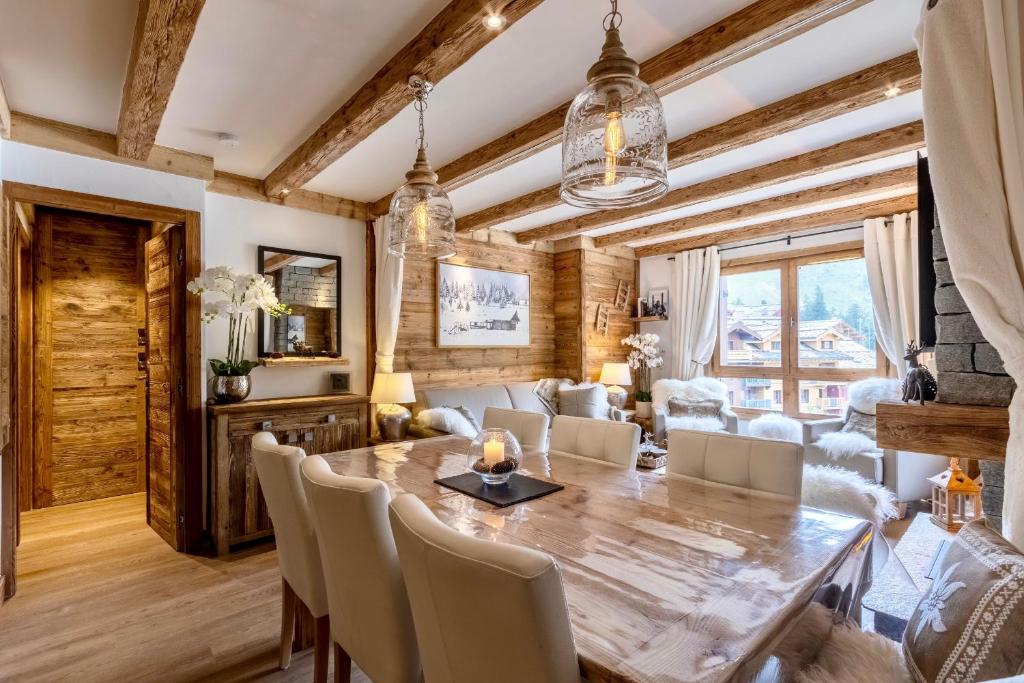 une salle à manger avec une table et des chaises en bois dans l'établissement Arc 1950, ambiance chalet luxe 5/7pers dans résidence 5* skis aux pieds avec SPA, à Arc 1950