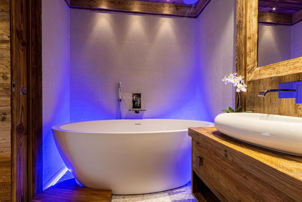 une salle de bain avec une baignoire blanche et un lavabo dans l'établissement Arc 1950, ambiance chalet luxe 5/7pers dans résidence 5* skis aux pieds avec SPA, à Arc 1950