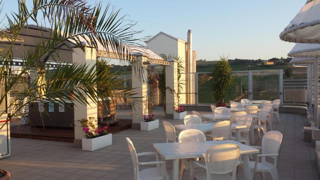 une rangée de tables et de chaises sur une terrasse dans l'établissement Hotel Nuovo Diana, à Senigallia