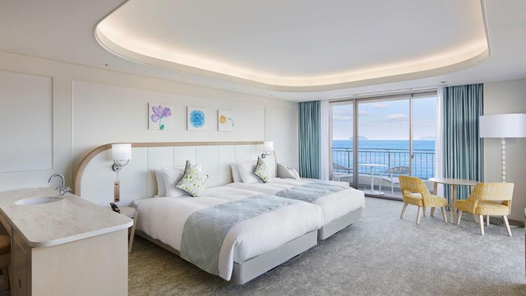 une chambre d'hôtel avec un grand lit et un balcon dans l'établissement Karatsu Seaside Hotel, à Karatsu