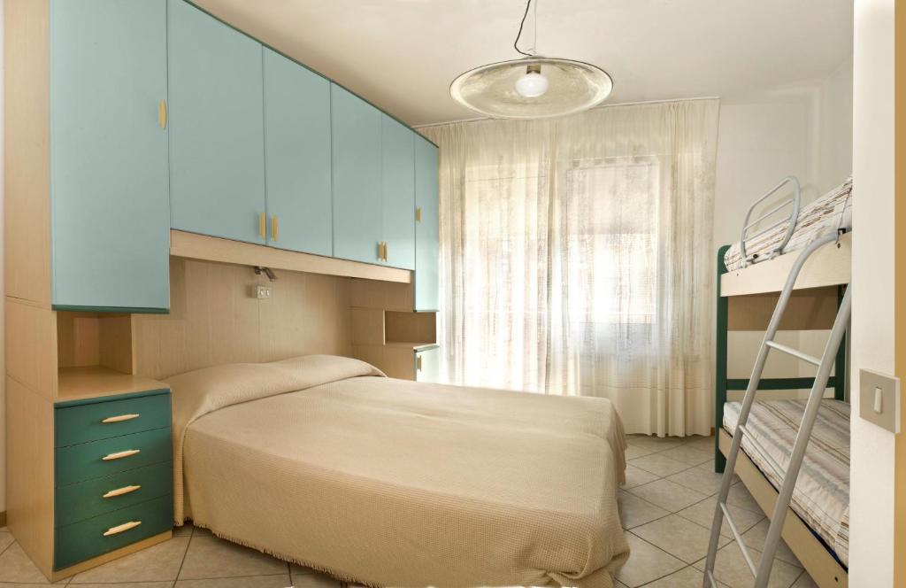 une chambre avec un lit et deux lits superposés dans l'établissement Villa Hanna, à Lido di Jesolo