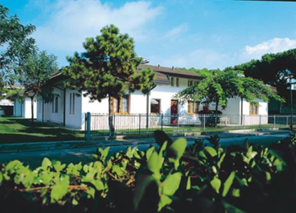 une maison blanche avec une clôture devant dans l'établissement Margherita Family Apartments, à Cavallino-Treporti