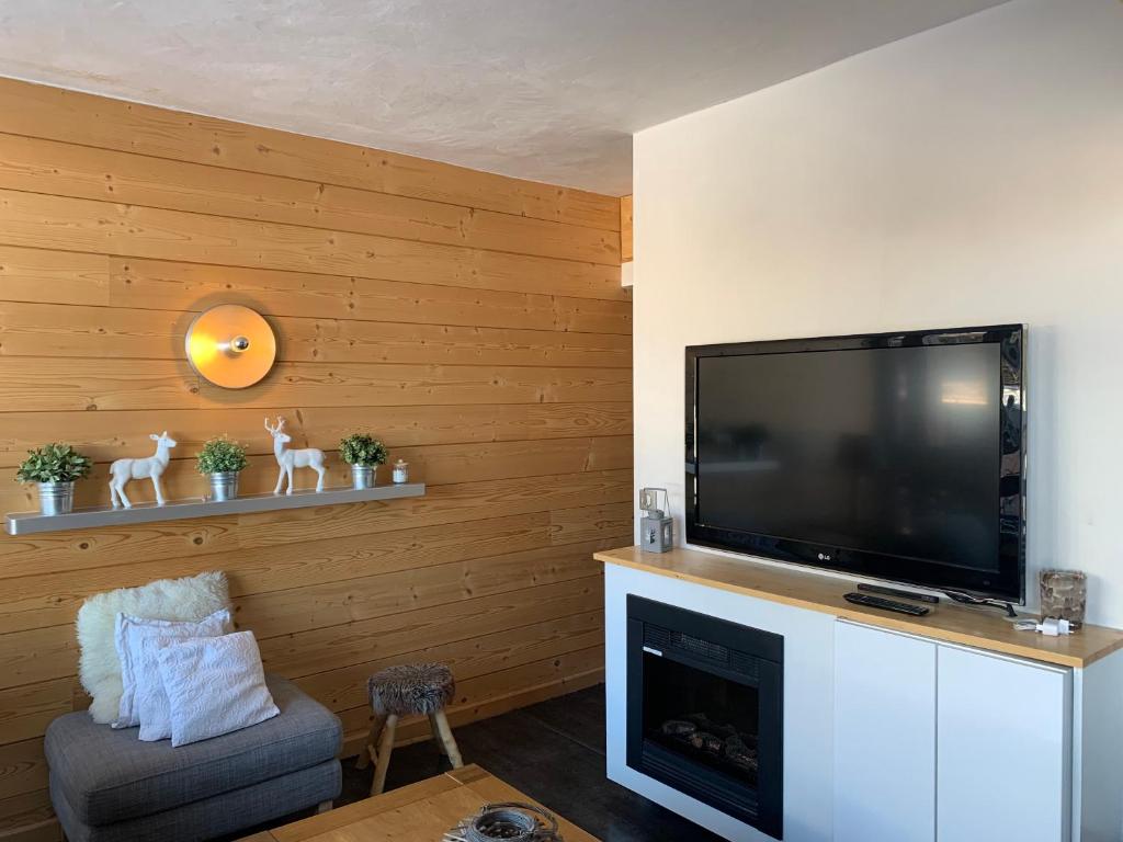 Il comprend un salon doté d'une télévision à écran plat et d'une cheminée. dans l'établissement Residence Pierra Menta, à Arc 1800