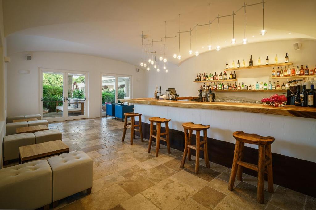 - un bar avec tabourets et un comptoir dans une pièce dans l'établissement Sant Efis Hotel, à Pula
