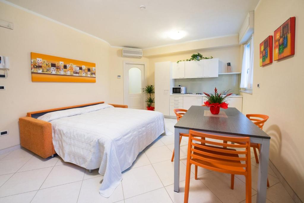 une chambre avec un lit et une table et une cuisine dans l'établissement Residence Colombo, à Viareggio