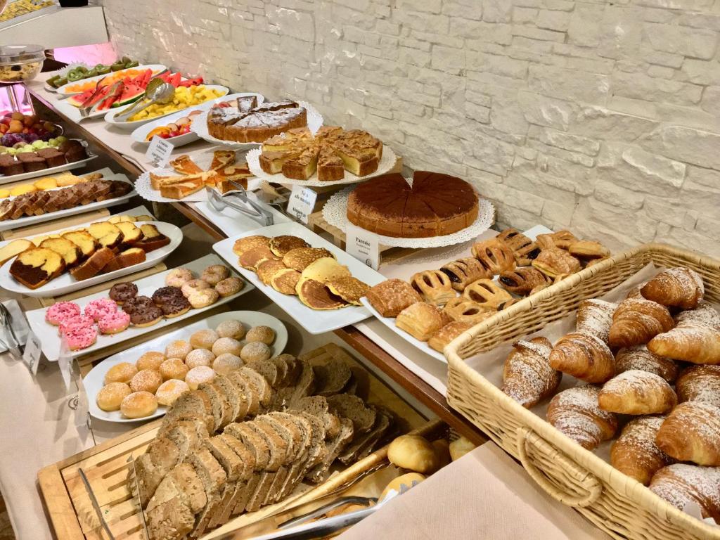 - une table avec de nombreux types de pain et de viennoiseries dans l'établissement Hotel Nazionale, à Lido di Jesolo