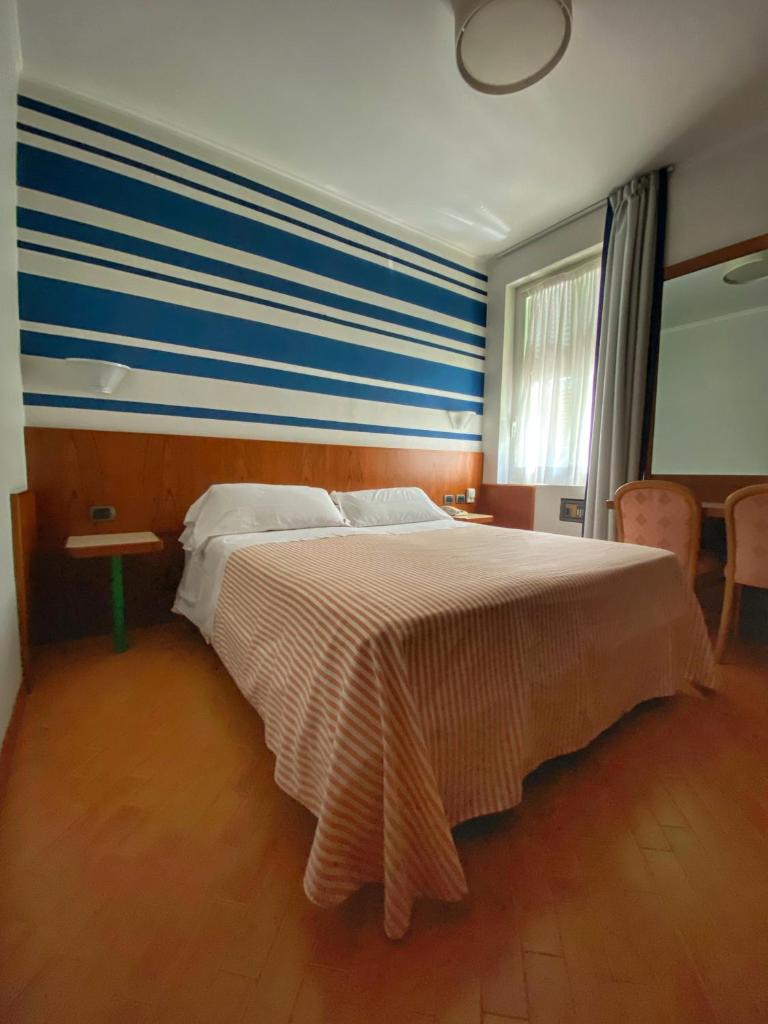 - une chambre avec un grand lit et un mur rayé dans l'établissement Regina Elena Dependance, à Santa Margherita Ligure