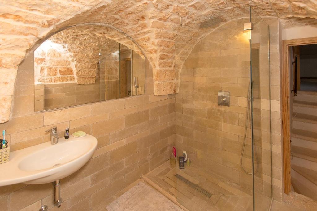 une salle de bain avec un lavabo et une douche en verre dans l'établissement Casa Amahoro, à Ostuni