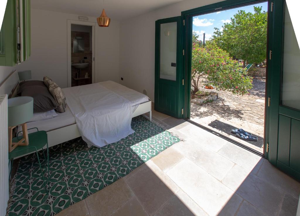 une chambre avec un lit et une porte coulissante en verre dans l'établissement Casa Amahoro, à Ostuni 49 autres photos