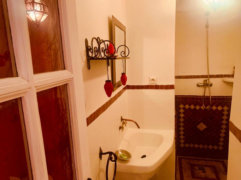 une salle de bain avec un lavabo, des toilettes et un miroir dans l'établissement Dar Zemrane, à Marrakech 28 autres photos