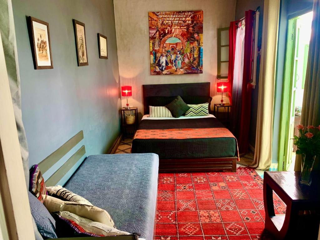 - une chambre avec 2 lits et un tapis rouge dans l'établissement Dar Zemrane, à Marrakech