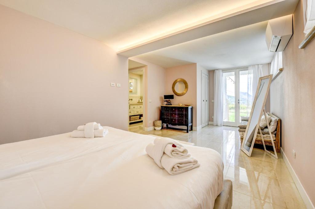 une chambre avec un grand lit blanc avec des serviettes dessus dans l'établissement Villa Caterina, à Salò