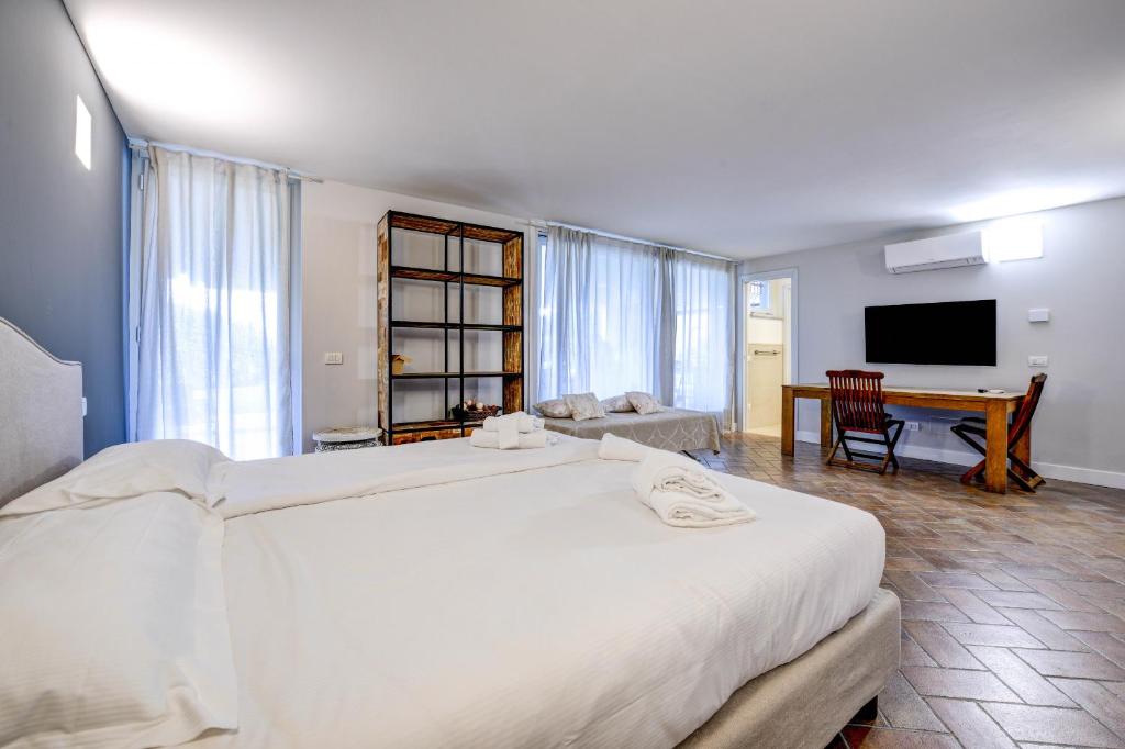 une chambre avec un grand lit blanc et un bureau dans l'établissement Villa Caterina, à Salò 62 autres photos