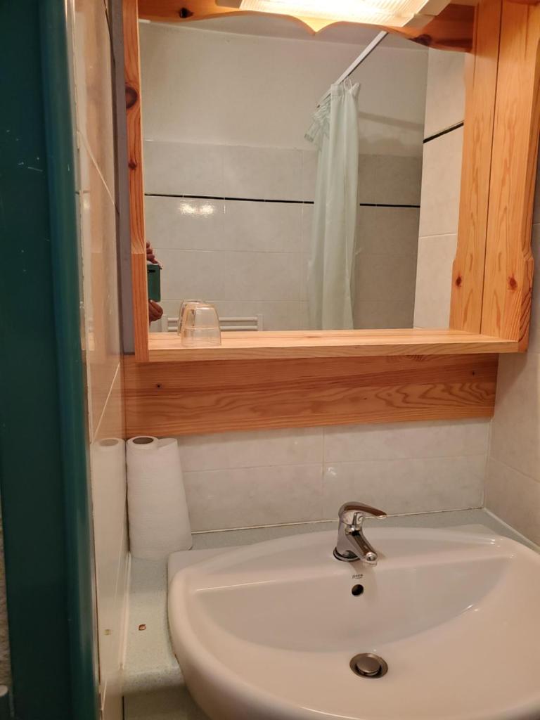 une salle de bain avec un lavabo et un miroir dans l'établissement Agréable appartement-Résidence Le Panoramic, aux Angles