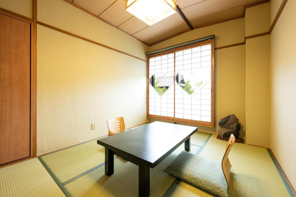 une salle à manger avec une table et une fenêtre dans l'établissement Yamadaya Ryokan, à Kyoto