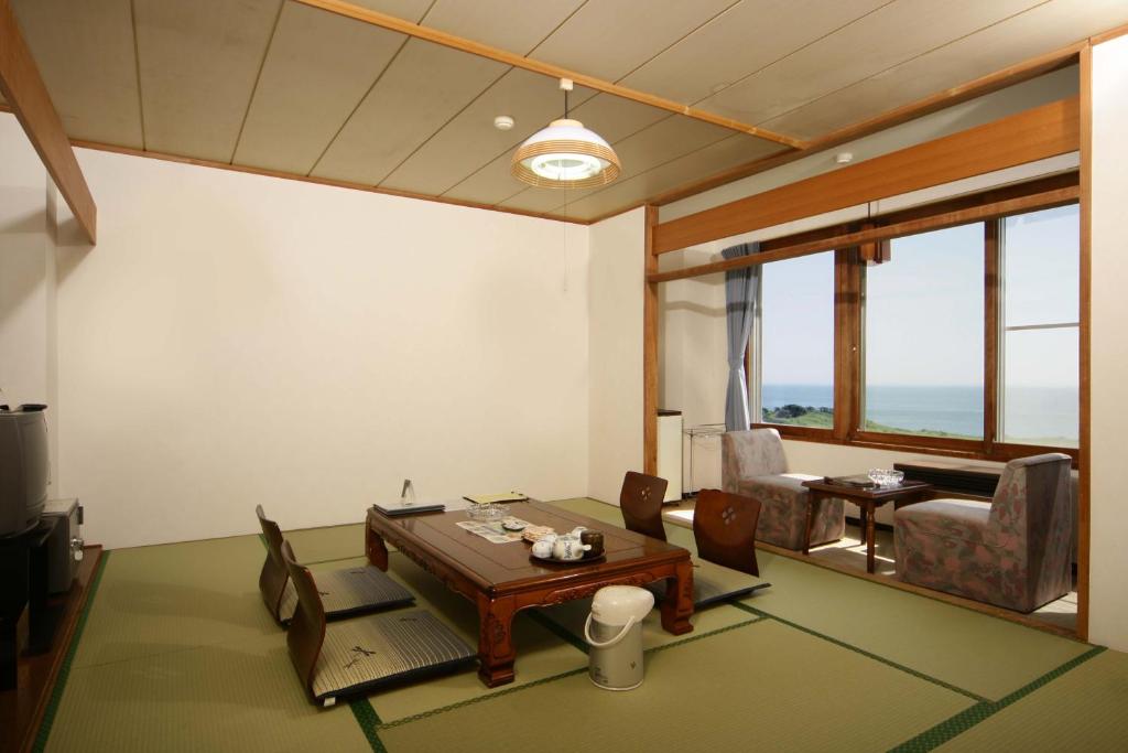 un salon avec une table et des chaises dans l'établissement Hotel Izumi, à Shiraoi