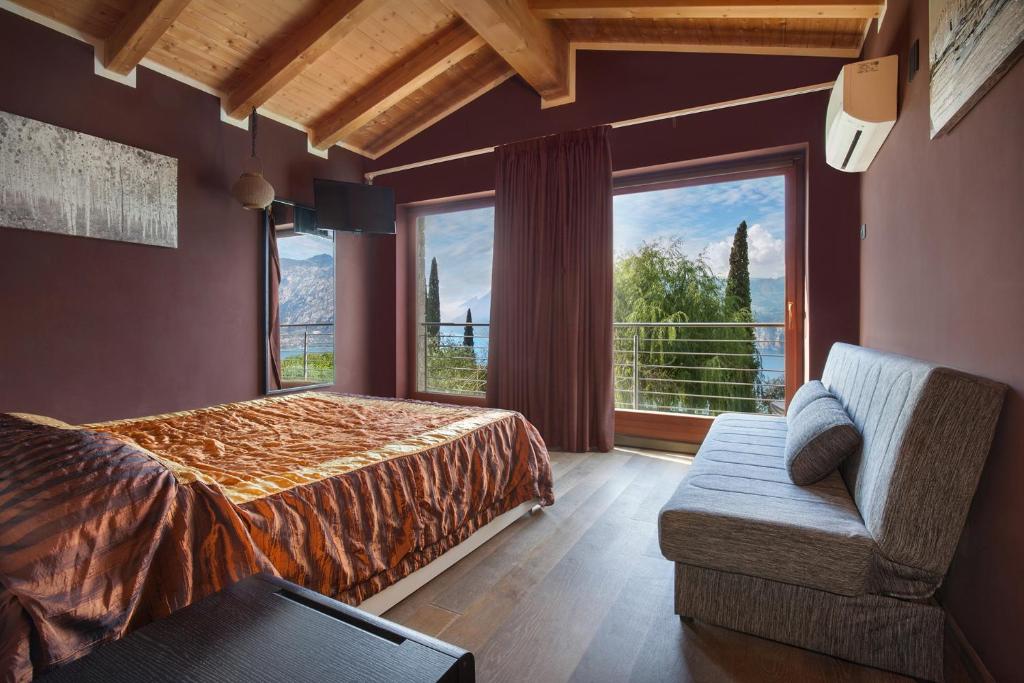 une chambre avec un lit et une grande fenêtre dans l'établissement Villa Cipressi - Luxuri Lounge -, à Malcesine