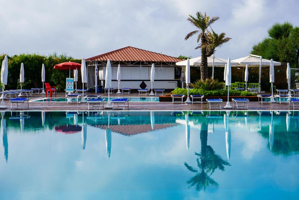 une grande piscine avec chaises et parasols dans l'établissement Puntaquattroventi, à Ercolano