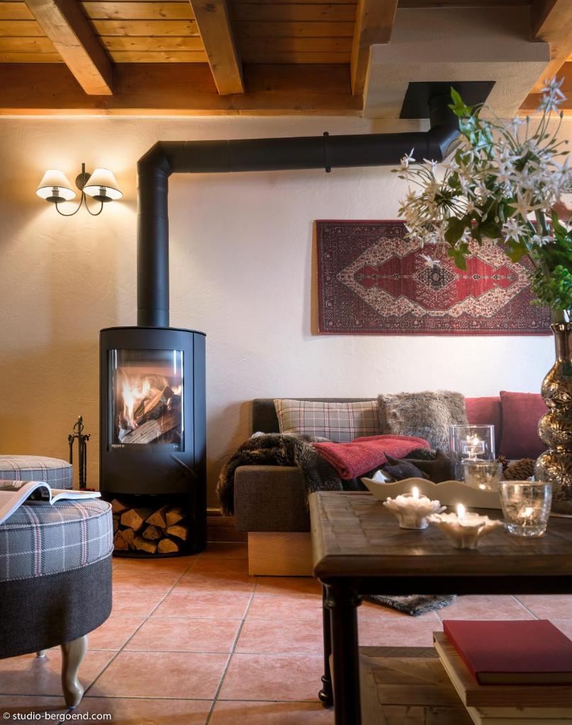 un salon avec une cheminée et un canapé dans l'établissement Le Hameau de la Sapinière, aux Menuires