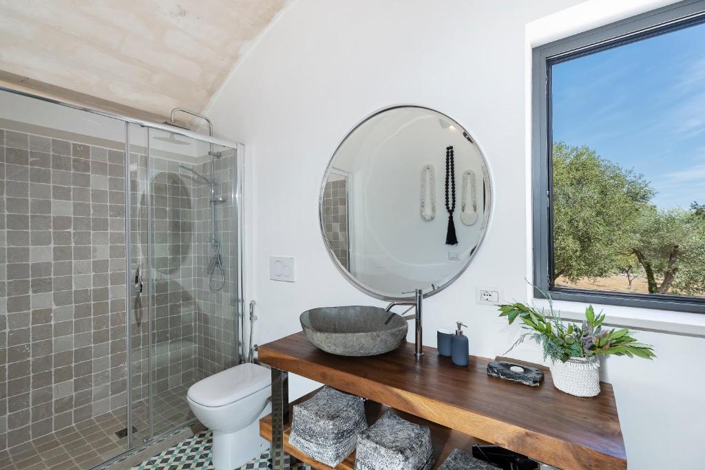 une salle de bain avec un lavabo et un miroir dans l'établissement trullo and lamia cinera, à Cisternino