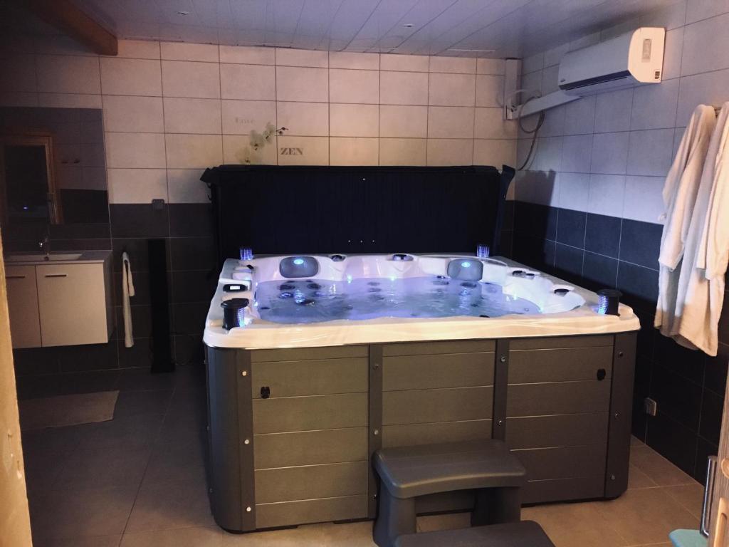 une salle de bain avec une baignoire au milieu d'une pièce dans l'établissement Gîte Spa Sauna Piscine CÔTÉ VERGER Merxheim Alsace, à Merxheim 17 autres photos