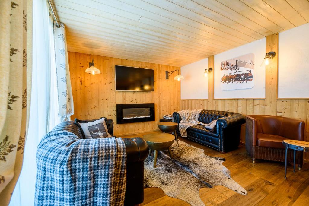 un salon avec deux canapés et une télévision dans l'établissement Hôtel Neste de Jade, à Saint-Lary-Soulan