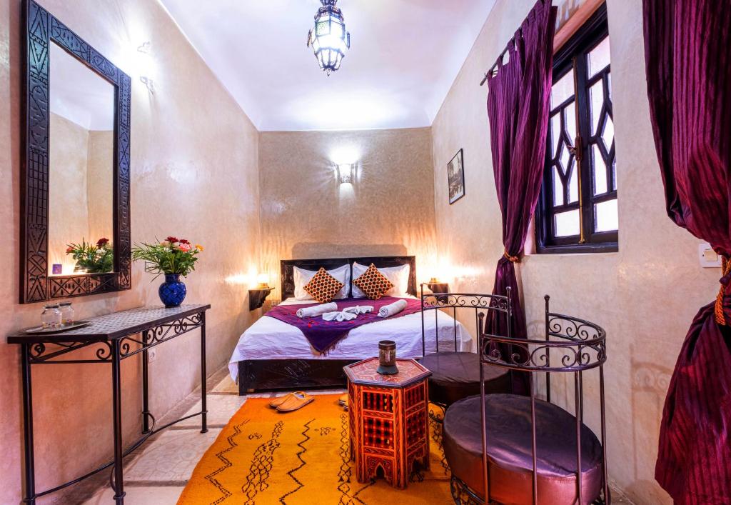 une chambre avec un lit, un miroir et une chaise dans l'établissement Riad ViewPoint, à Marrakech 32 autres photos