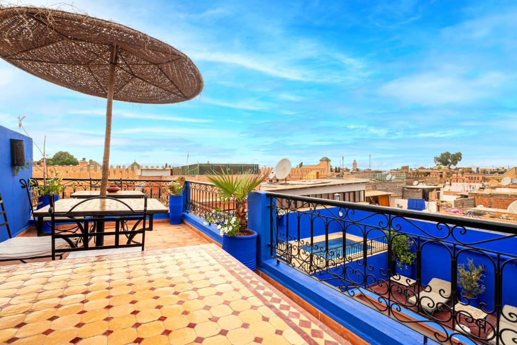 - un balcon bleu avec une table et un parasol dans l'établissement Riad ViewPoint, à Marrakech