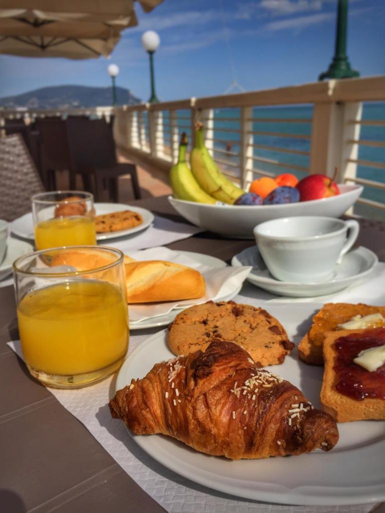 une table garnie d'assiettes de nourriture et de jus d'orange dans l'établissement Hotel Brigantino Non Dista, à Porto Recanati