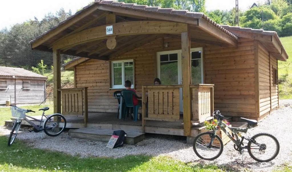 une cabane en bois avec deux vélos garés devant elle dans l'établissement Le Verdoyant, à Thenon