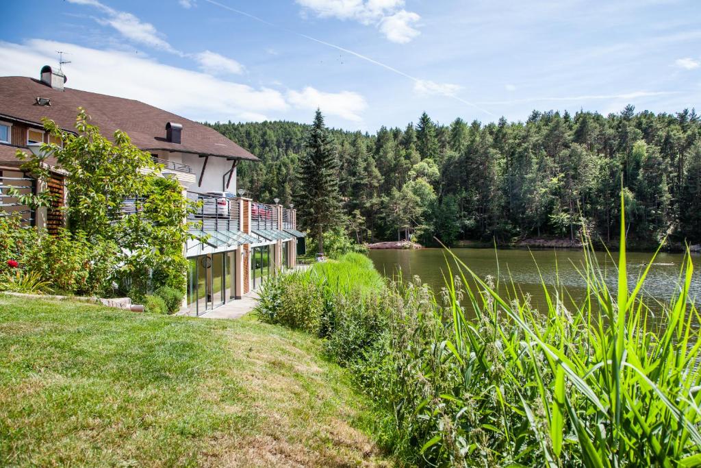 une maison sur la rive d'un lac dans l'établissement Hotel Am Wolfgrubenersee, à Soprabolzano