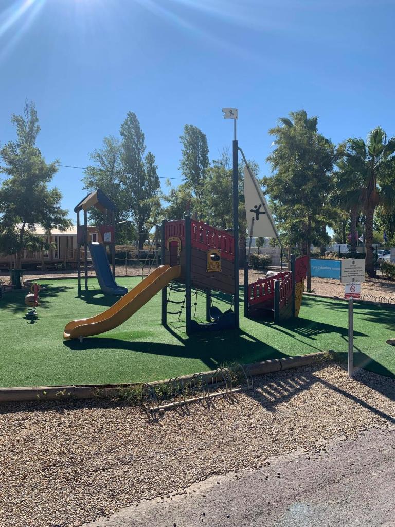 une aire de jeux avec un toboggan dans un parc dans l'établissement Camping Le Montourey, à Fréjus