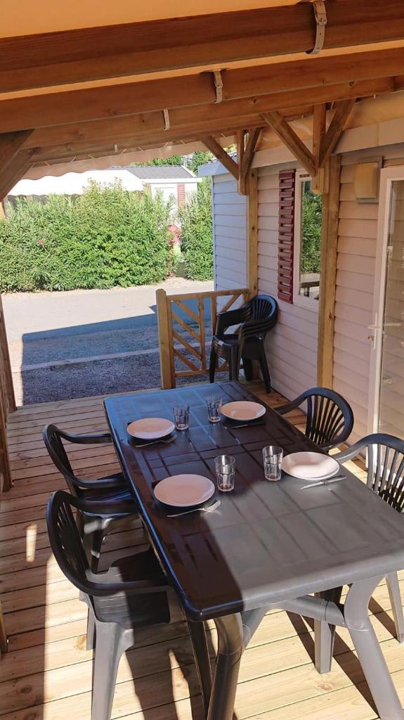 une table noire sur une terrasse avec des chaises noires dans l'établissement Camping Le Montourey, à Fréjus