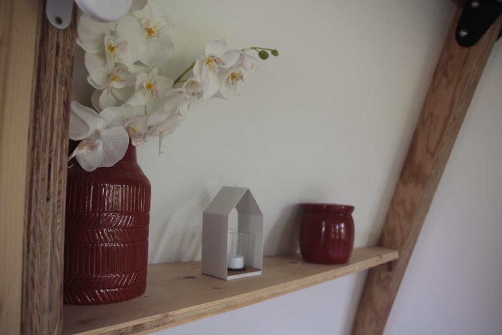 une étagère en bois avec un vase de fleurs. dans l'établissement nuit étoilée, à Mondragon