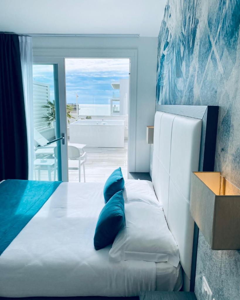 une chambre avec un lit avec des oreillers bleus dessus dans l'établissement Hotel Greif, à Lido di Jesolo