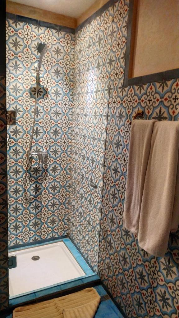 La salle de bains est pourvue d'une douche et d'une serviette. dans l'établissement Riad Basma Marrakech, à Marrakech 32 autres photos