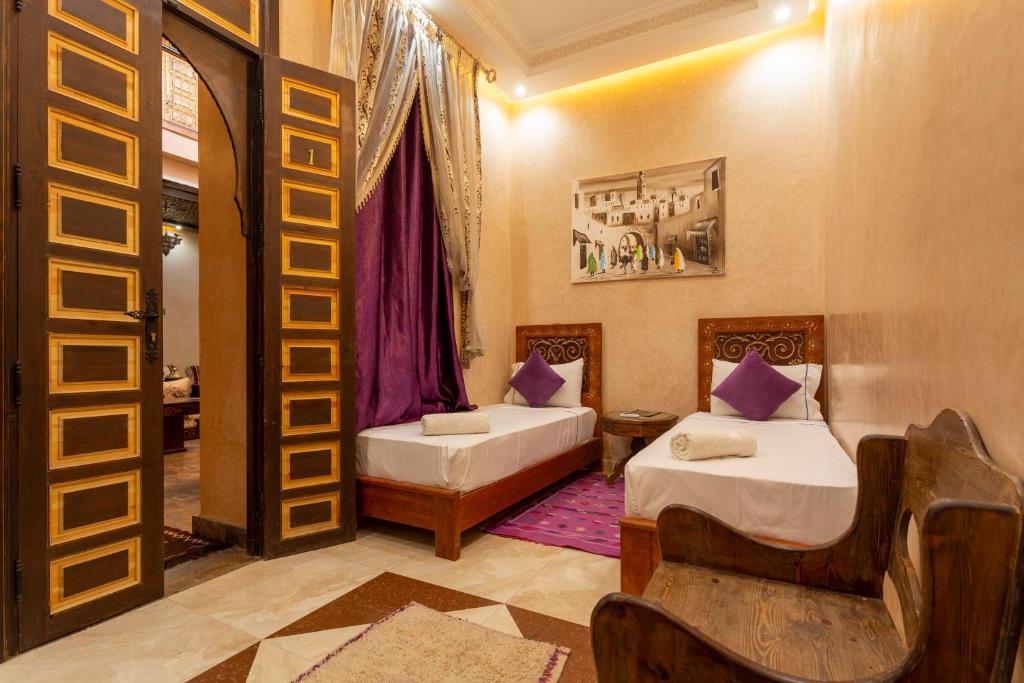 - une chambre avec 2 lits et une porte menant à une pièce dans l'établissement Riad Alice Terrace & Spa, à Marrakech