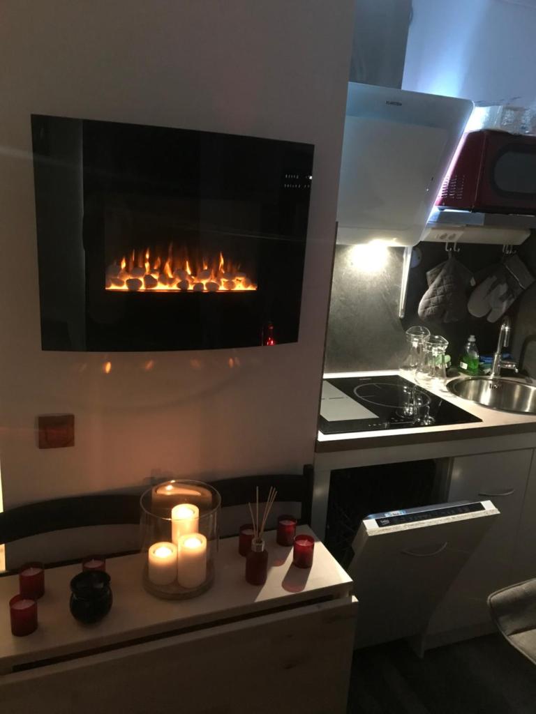une cuisine avec une cheminée et des bougies sur un comptoir dans l'établissement Bienvenue chez nous, à Arc 2000 17 autres photos