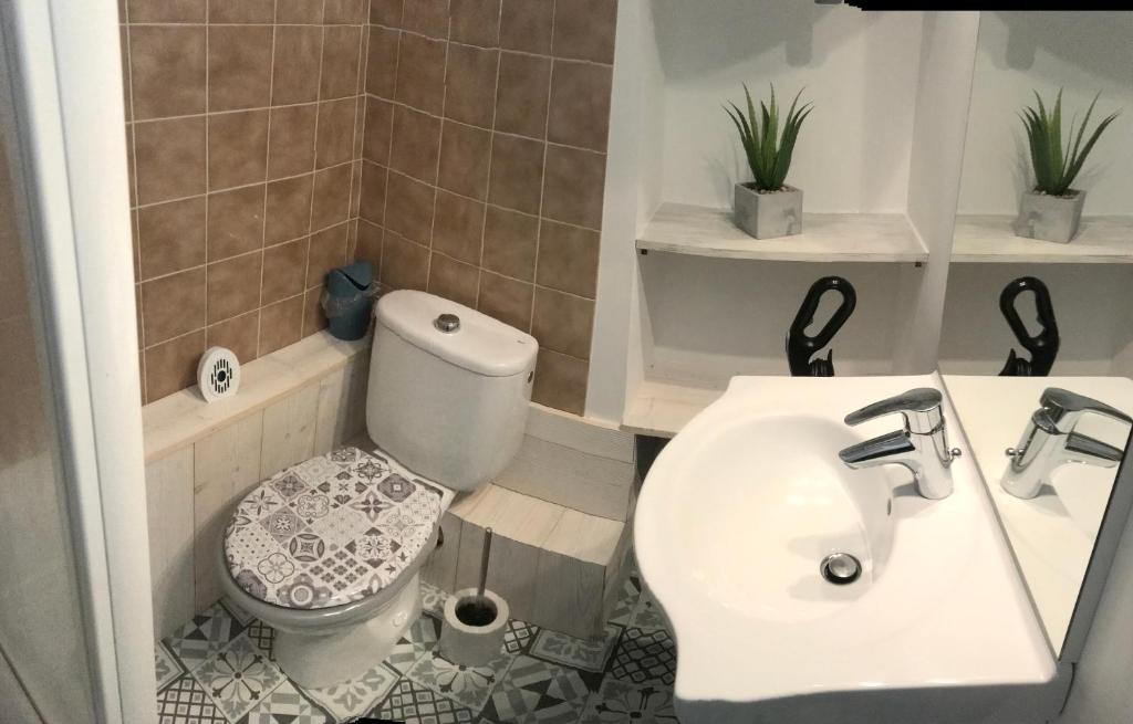 une salle de bain avec des toilettes blanches et un lavabo dans l'établissement Bienvenue chez nous, à Arc 2000