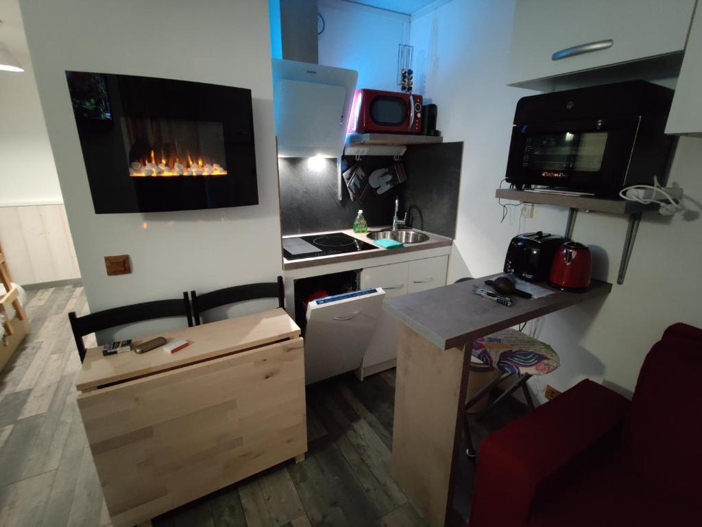Il comprend une petite cuisine équipée d'une cuisinière et une télévision murale. dans l'établissement Bienvenue chez nous, à Arc 2000