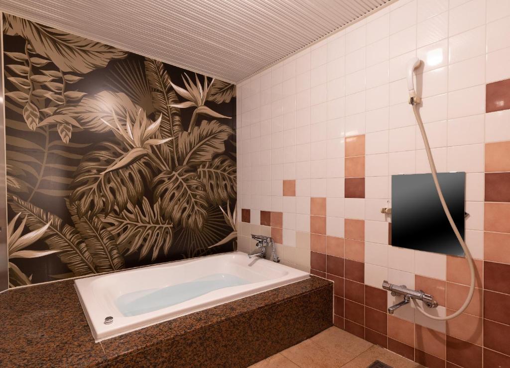 La salle de bains est pourvue d'une baignoire et d'un mur en carrelage. dans l'établissement ホテル ロコガーデン 小牧, à Toyoyama 48 autres photos