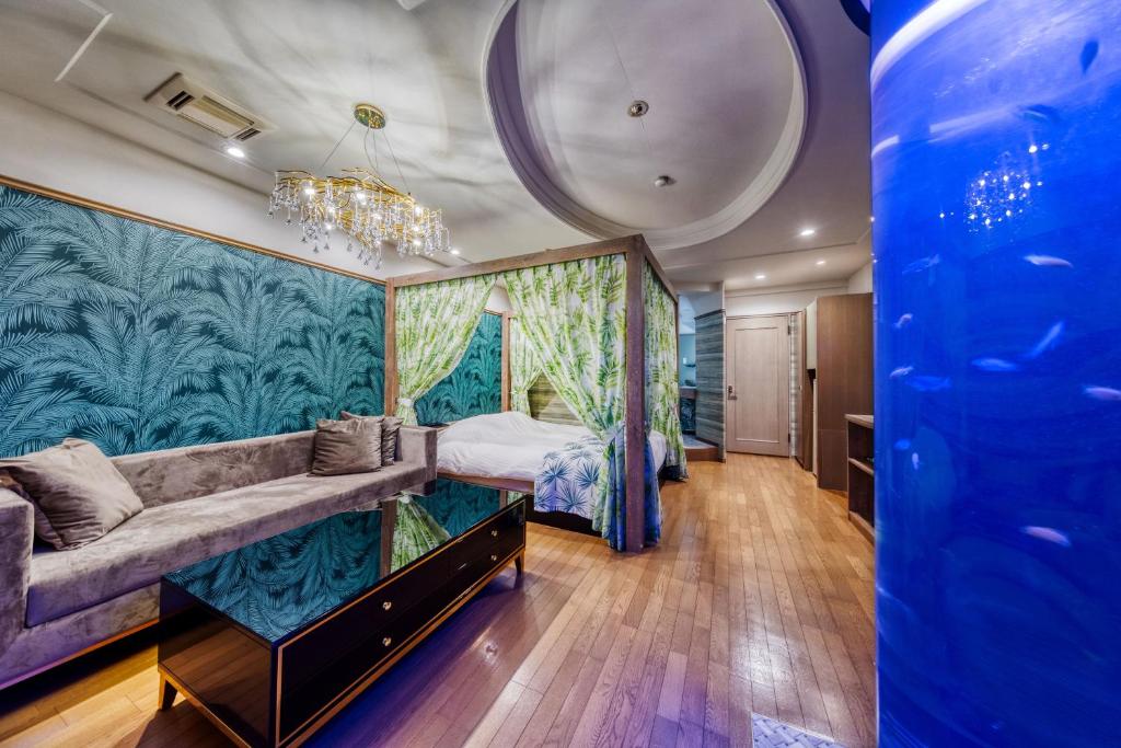 une chambre d'hôtel avec un lit et un canapé dans l'établissement HOTEL ARTIA DINOSAUR GIFU -Adult Only, à Rokujō