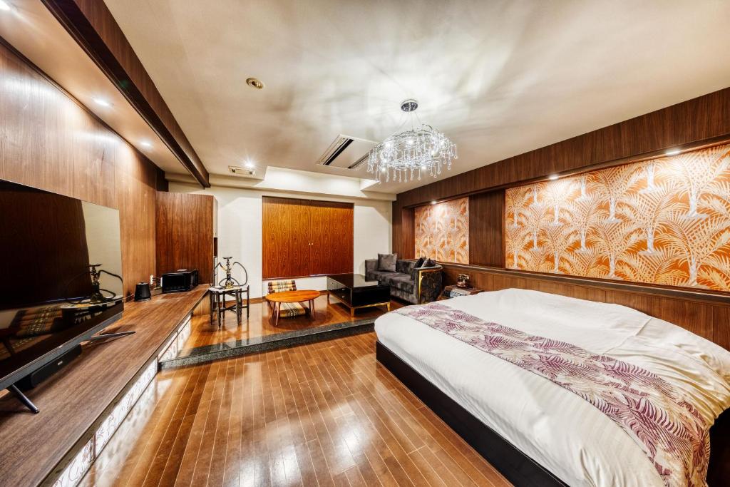 une chambre avec un lit et une télévision à écran plat dans l'établissement HOTEL ARTIA DINOSAUR GIFU -Adult Only, à Rokujō 12 autres photos