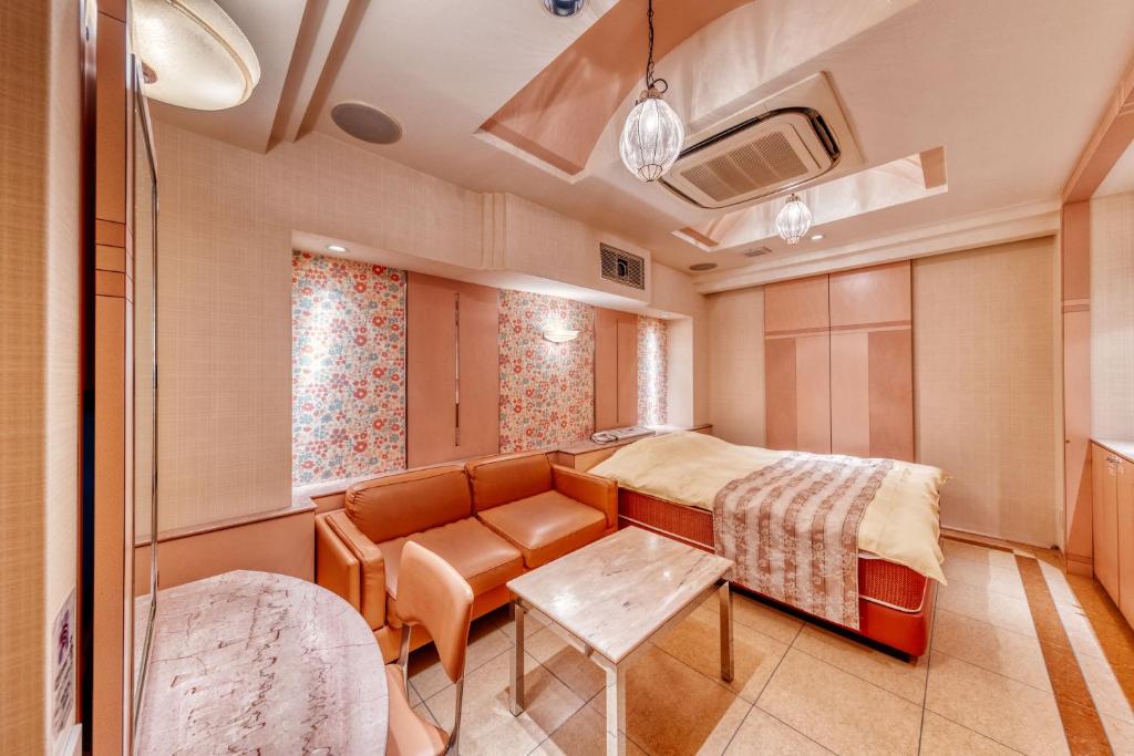 une chambre avec un lit, un canapé et une table dans l'établissement HOTEL sala del rey namba -Adult Only, à Osaka
